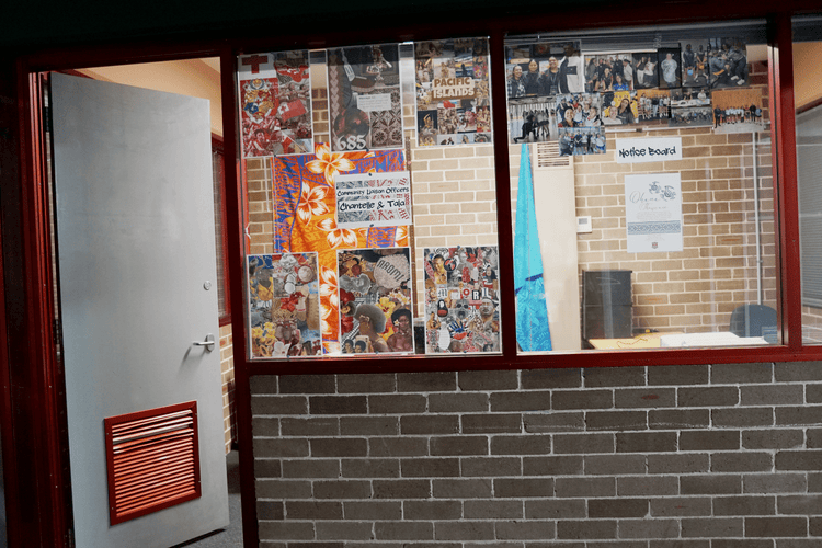 External view of an office with pictures on the window and the door open.