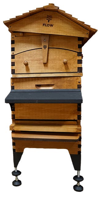 A wooden beehive with a tiered roof.