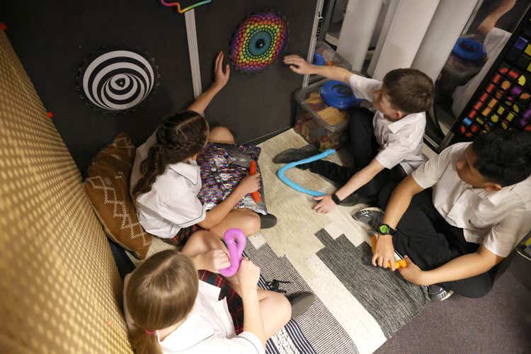 Four students in a sensory pod using the fidget components.