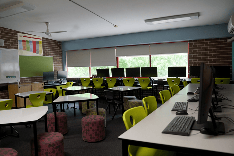 Computers on tall desks around the edges of the room with green chairs, and lower tables with ottomans in the centre.